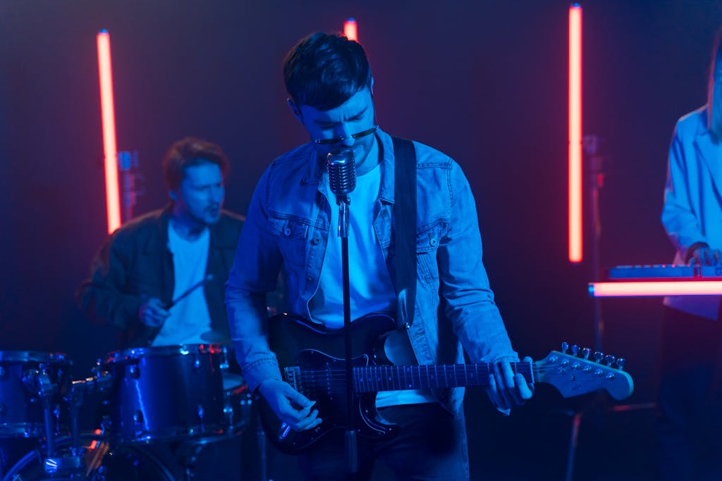 A band performing live on stage with neon lights and electric guitars.
